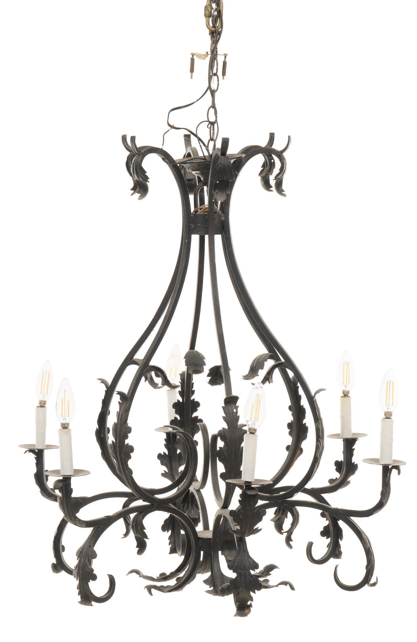 Wrought Iron Chandelier: Wrought iron chandelier, with six arms, ending in six electric lights, with foliate accents throughout, suspended on chain height 36 in. x diameter 33 in. We happily provide seamless shipping services