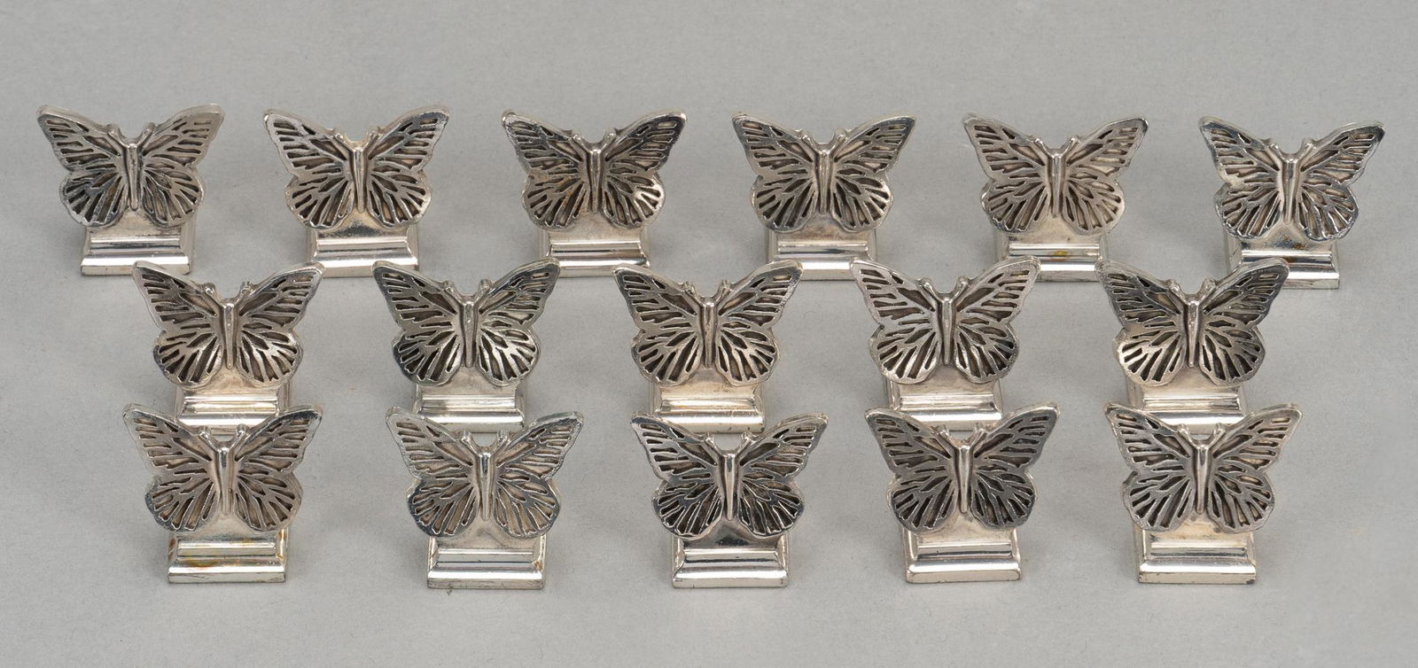 (16) Christofle (FRA) Silverplate Butterfly Place Card Holders: Sixteen Christofle (France) silverplate butterfly place card holders, featuring pierced wing details, marked on base height 1 in. x width 0.5 in. x depth 1 in. / each Provenance: Contents from a his