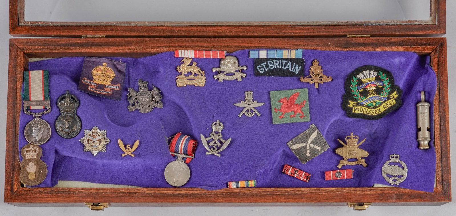 Display of British Militaria & Ephemora: Includes: -Middlesex Regiment Blazer badge, Royal Gurkha patch, British Commonwealth Forces patch, Welsh Dragon patch -British WWI whistle -Canadian Windsor Regiment badge -Royal Artillery badge, Roya
