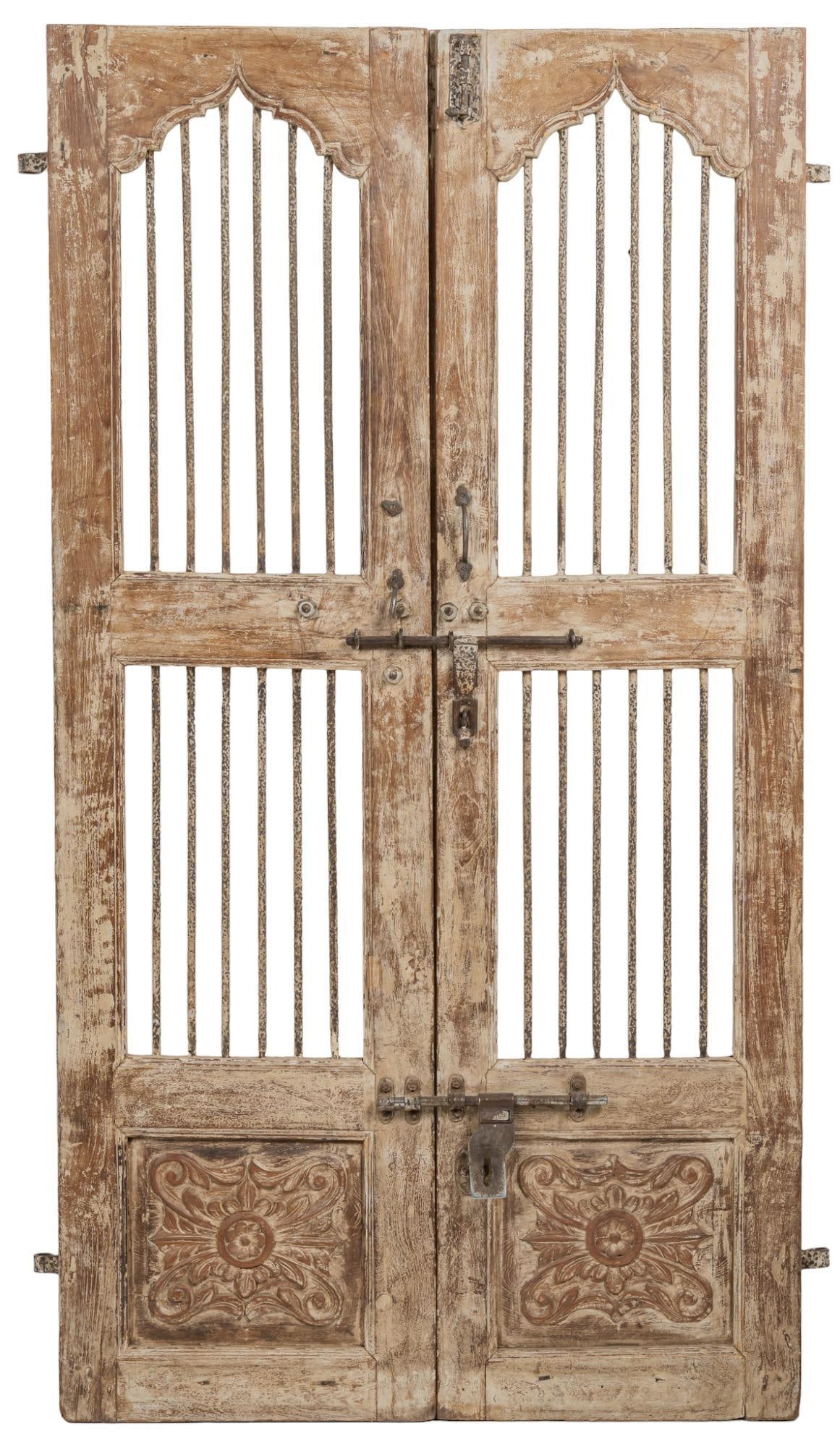 Pair of Teak Gates, White: Pair of teak gates, featuring carved medallion design, with two sliding latch locks, iron accents and hardware, with remnants of white paint height 73 in. x width 19 in. x depth 2 in. We happily provi