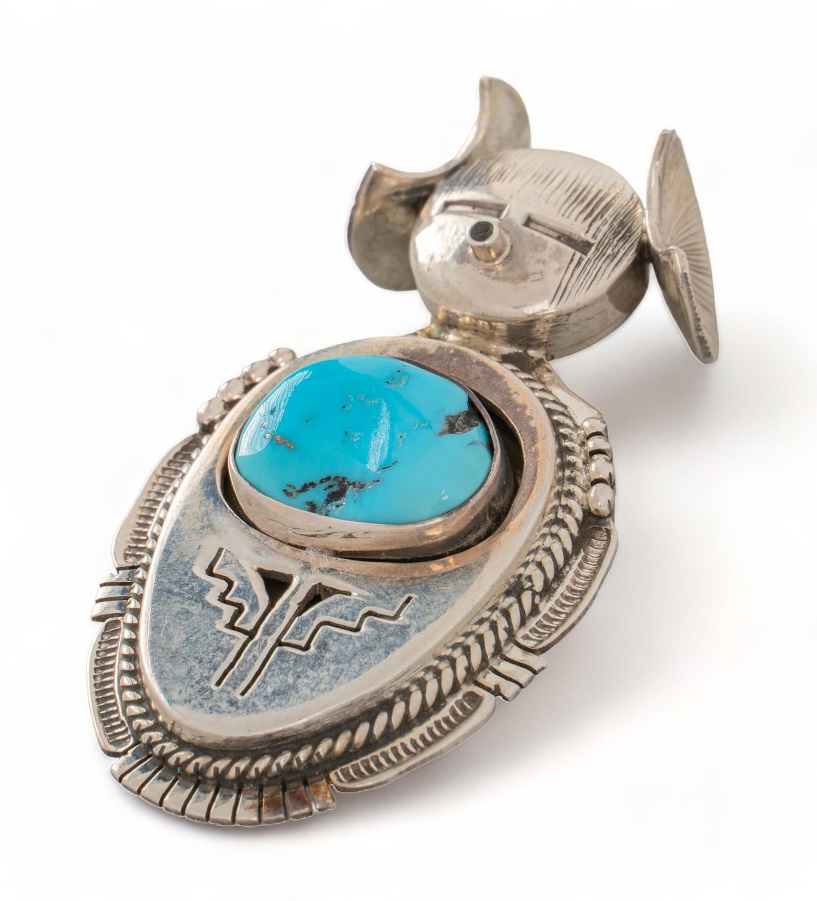 Bennie Ration Sterling Silver and Turquoise Kachina Doll Broach: Bennie Ration sterling silver and turquoise kachina doll broach, robins egg blue polished turquoise set centrally within Hopi kachina figure, rope border, traditional Navajo patterns, marked length 2