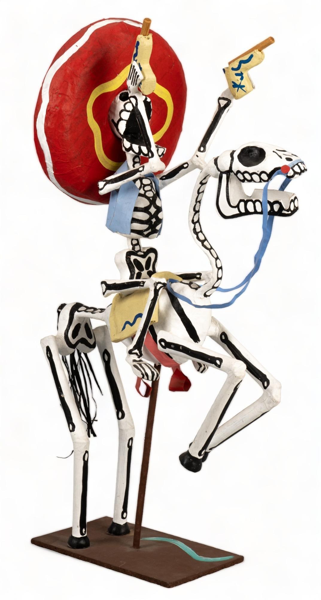 Papier Mache Vaquero with Guns: Papier mache sculpture, depicting a vaquero on a reading horse, firing pistols, with painted accents height 23.5 in. x width 7.5 in. x depth 14.5 in. Provenance: Property from the life-long Mexican