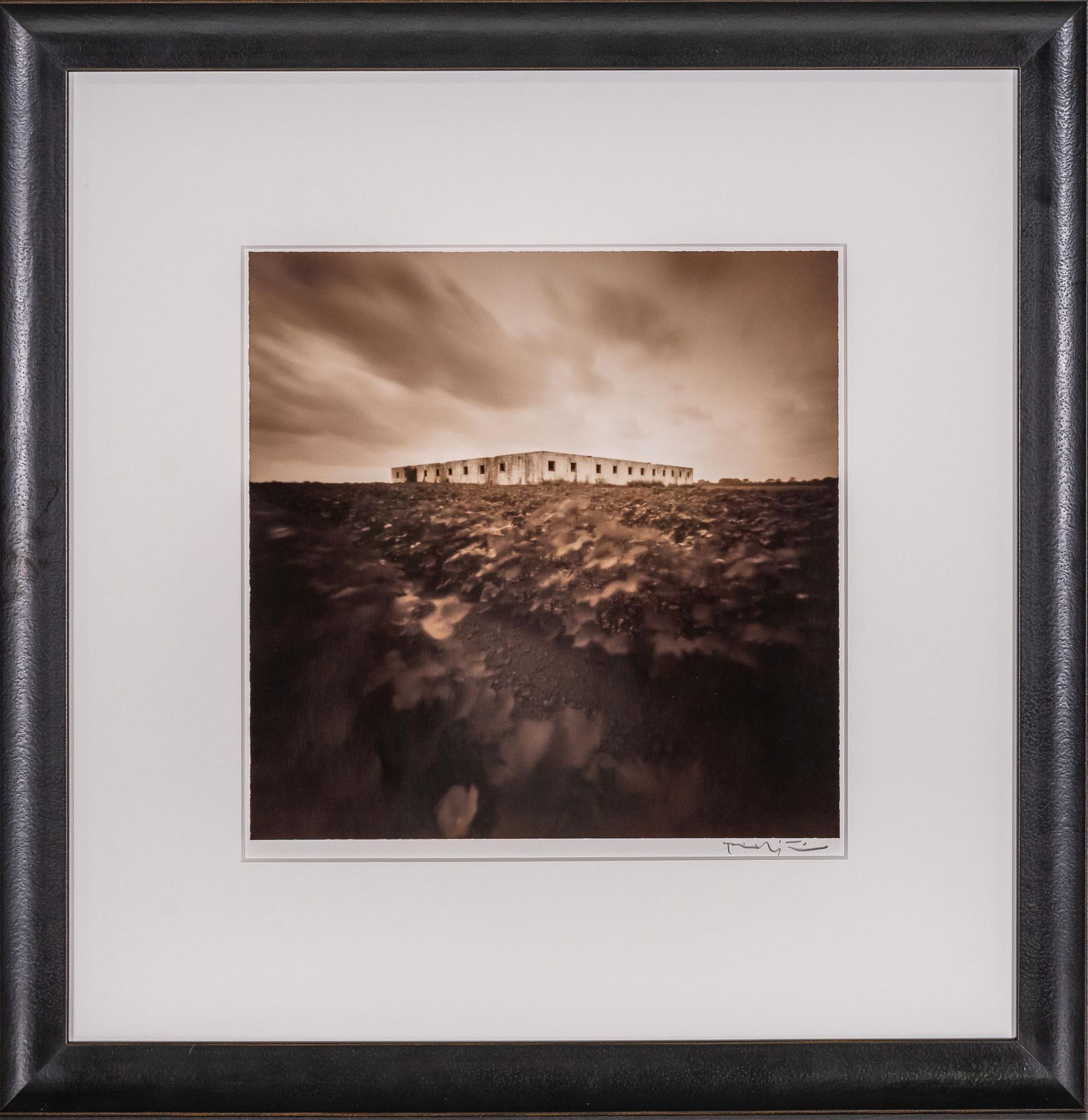 House of the Workers, Signed Bill Wittliff Photograph: Bill Wittliff (1940-2019, USA) La Vida Brinca: House of the Workers, 1998, photograph of an seemingly abandoned building across a field of foliage, framed and matted by John Scott (Austin, Texas) unde