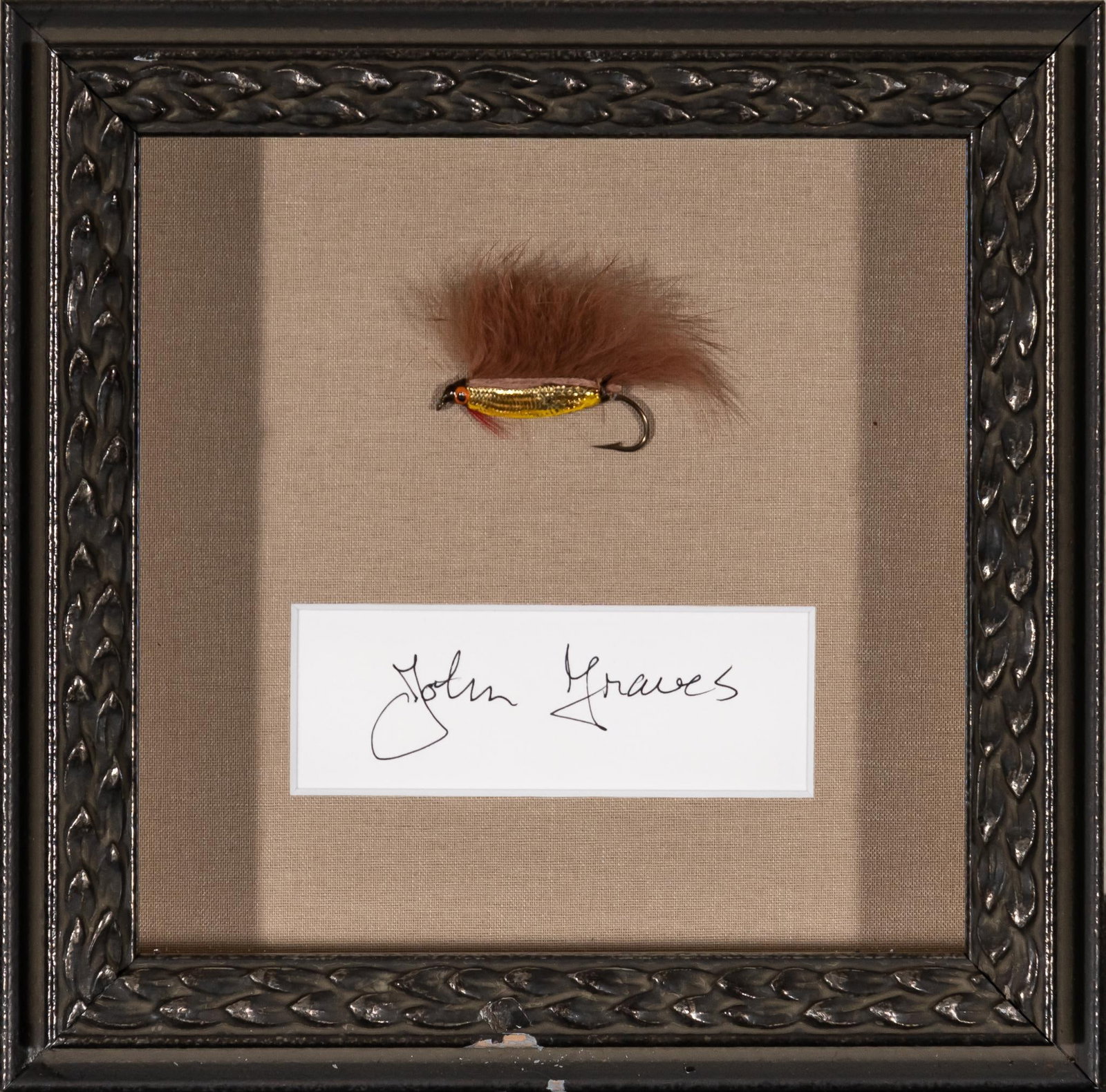 John Graves, Fishing Lure with Signature: Fishing lure with gold-toned scales, tied by American writer John Graves, above his signature, framed frame: 7.5 in. x 7.5 in. Provenance: Property from the personal estate collection of noted photogr