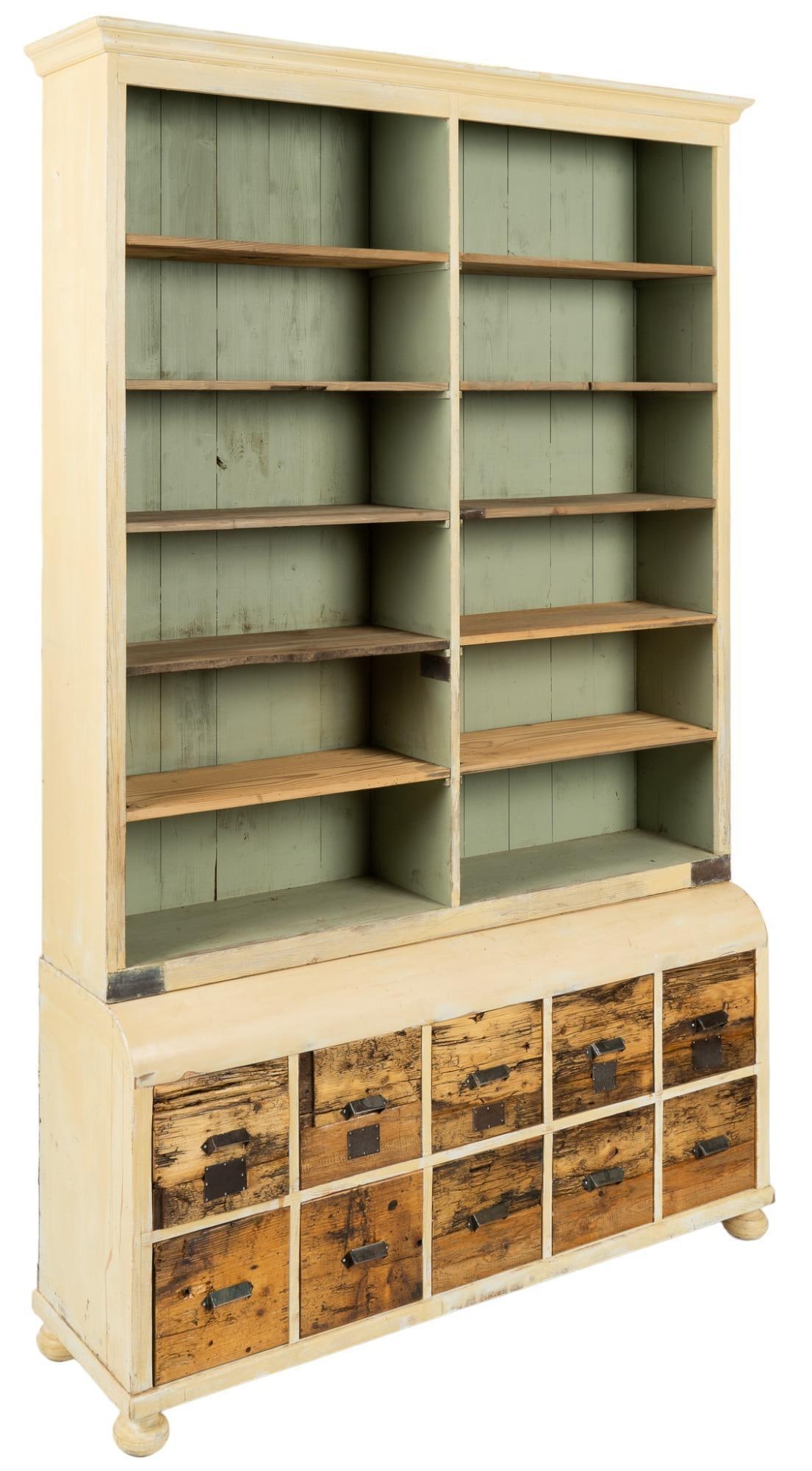 Apothecary Shop Display Cabinet: Apothecary shop display cabinet, featuring top section with ten shelves, above bottom section with ten drawers with metal pulls, rising on bun feet height 110 in. x width 68 in. x depth 18 in. We happ