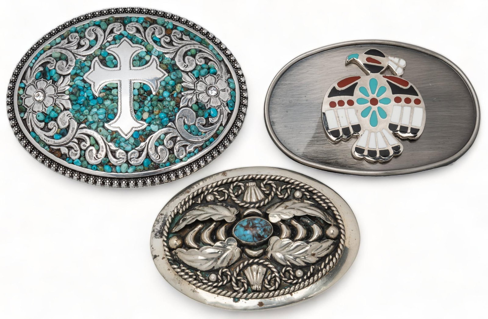 (3) Southwestern Belt Buckles: Three (3) Southwestern belt buckles, one (1) alpaca silver buckle with turquoise inlay and leaf motifs, one (1) Blazin Roxx turquoise stone cross belt buckle with floral scroll work, one (1) vintage i