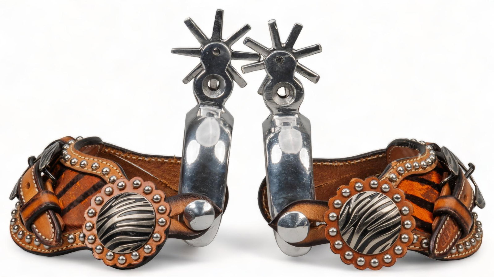 Pair of Mexican Chihuahua Spurs: Pair of Mexican Chihuahua spurs, with leather heal straps featuring animal print details, with metal stud accents spur length: 5 in. x heel width: 3.5 in. rowel diameter: 2 in. Provenance: Property fr