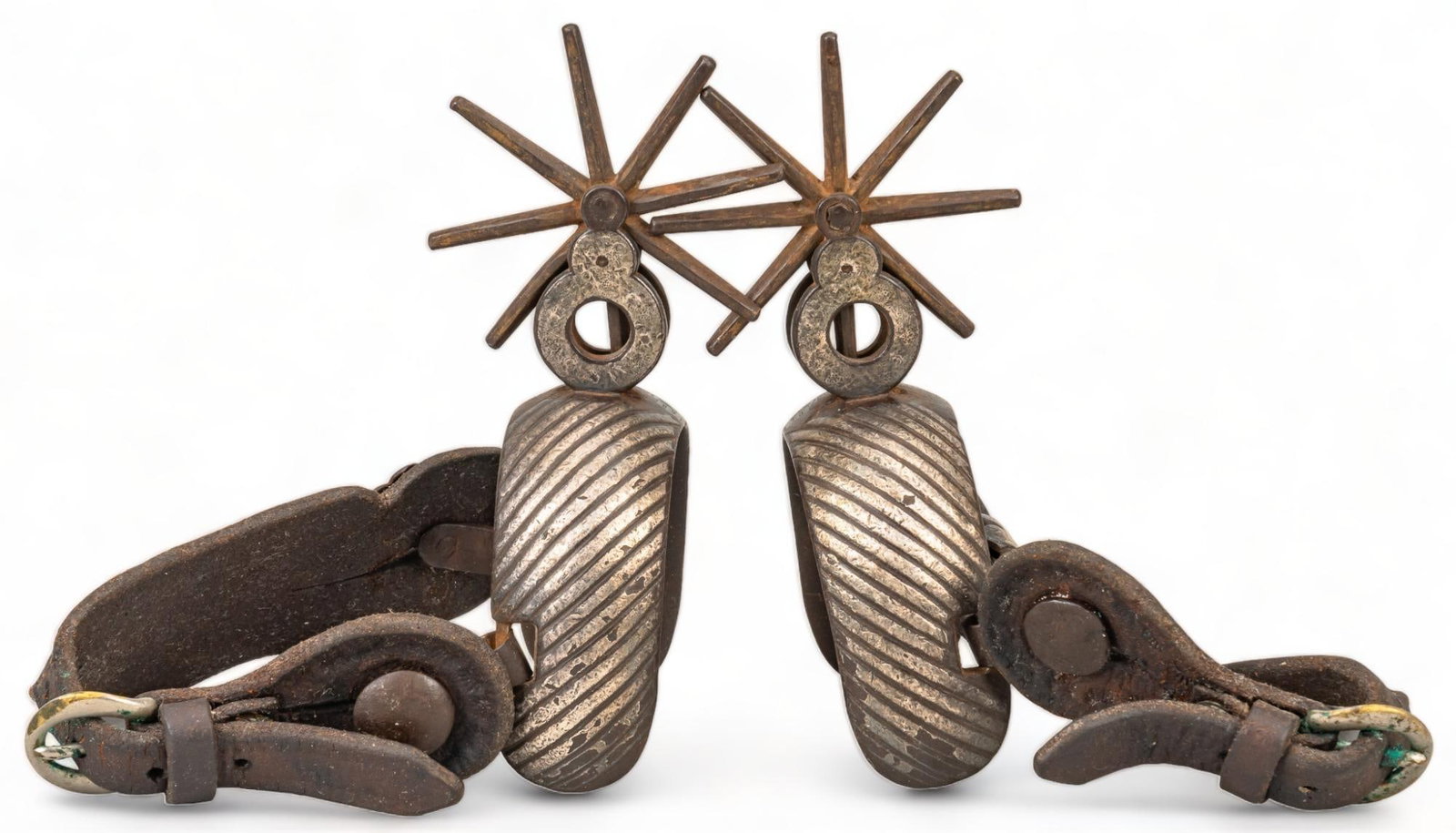 Pair of Chihuahua Spurs: Pair of Chihuahua spurs, with silver mounted heel bands, leather heel straps, eight point rowels, circa 1930-40s height 6.5 in. x width 4 in. x depth 3 in. Provenance: Property from a Truchas, New Mex