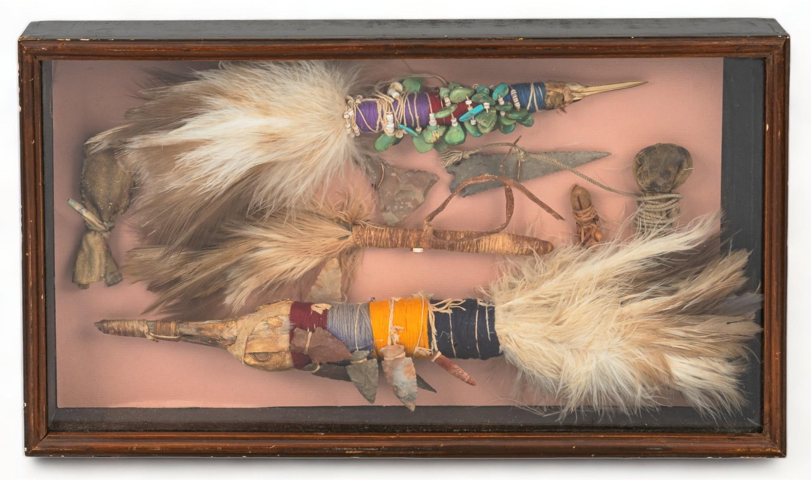 Collection of Navajo Artifacts: Collection of framed Navajo artifacts, to include one talking stick, two shaman sticks, three medicine bags, and two points, point and drill tips, with feather and leather details height 11.5 in. x wi