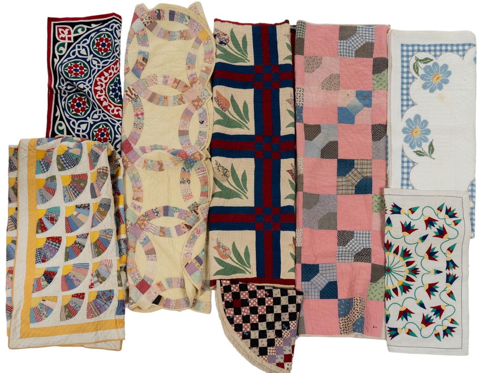 Collection of (8) Quilts: Collection of eight quilts, to include examples with wedding ring, tulips, and fan patterns, featuring one signed example, dated 1987 7'7" x 6' / largest We happily provide seamless shipping service