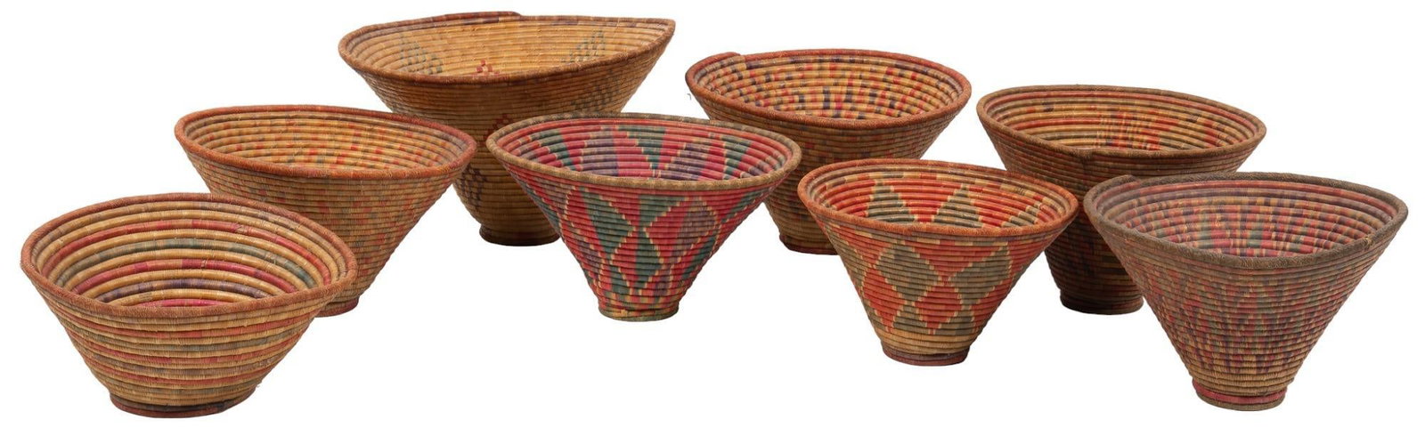 Set of (8) Hand-Woven Baskets: Set of eight hand-woven coiled baskets, with polychrome designs height 15 in. x width 26 in. x depth 27 in. / largest Provenance: Property from the estate of long-time antiques dealer Nancy Kendall, B