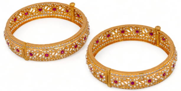 (2) 22K Gold Seed Pearl and Ruby Screw Hinge Bangles: Two (2) seed pearl and ruby 22K yellow gold screw hinge bangle bracelets, floral design, clear crystal border, electronically tested circumference 7.5 in. total weight: 60.3 grams Provenance: