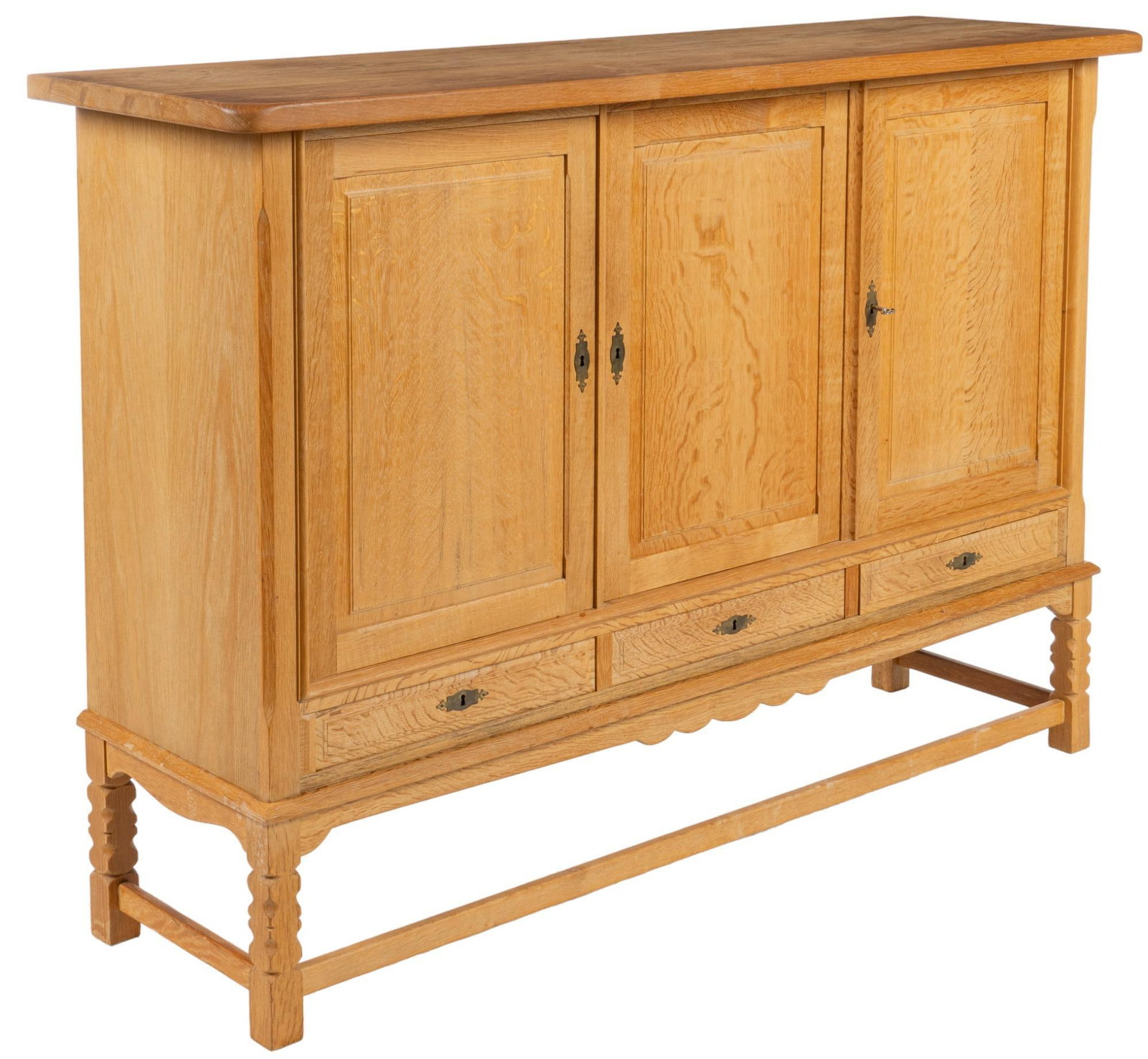 Henning Kjaernulf Style Credenza: Danish Mid-Century credenza / server, in the style of Henning Kjkaernulf, with thick top, over three cabinet doors, scalloped apron, featuring carved legs, connected with stretcher, to include key hei