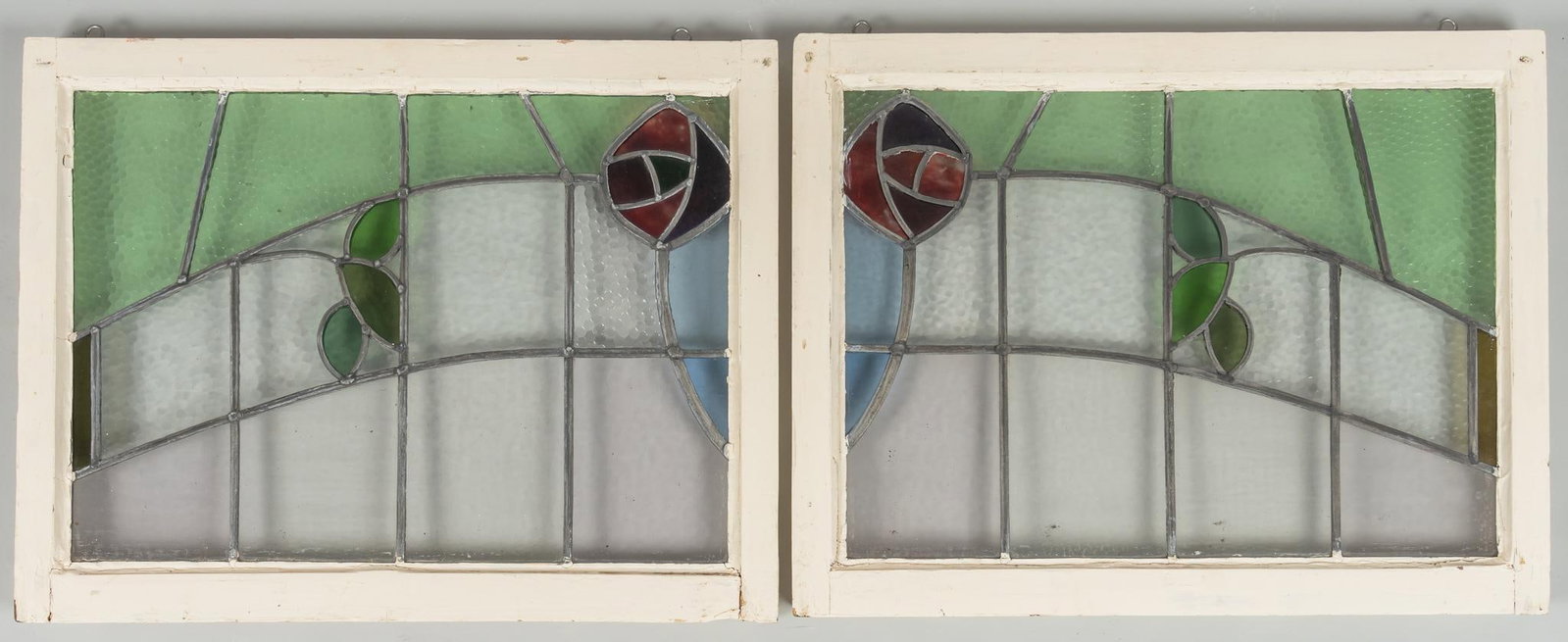 (2) Rosette Stained Glass Windows: Two (2) rosette stained glass windows, corner rosette design with leaves, leaded panes height 22.5 in. x width 23.5 in. x depth 2 in. Provenance: Property from the collection of a San Antonio, Texas g