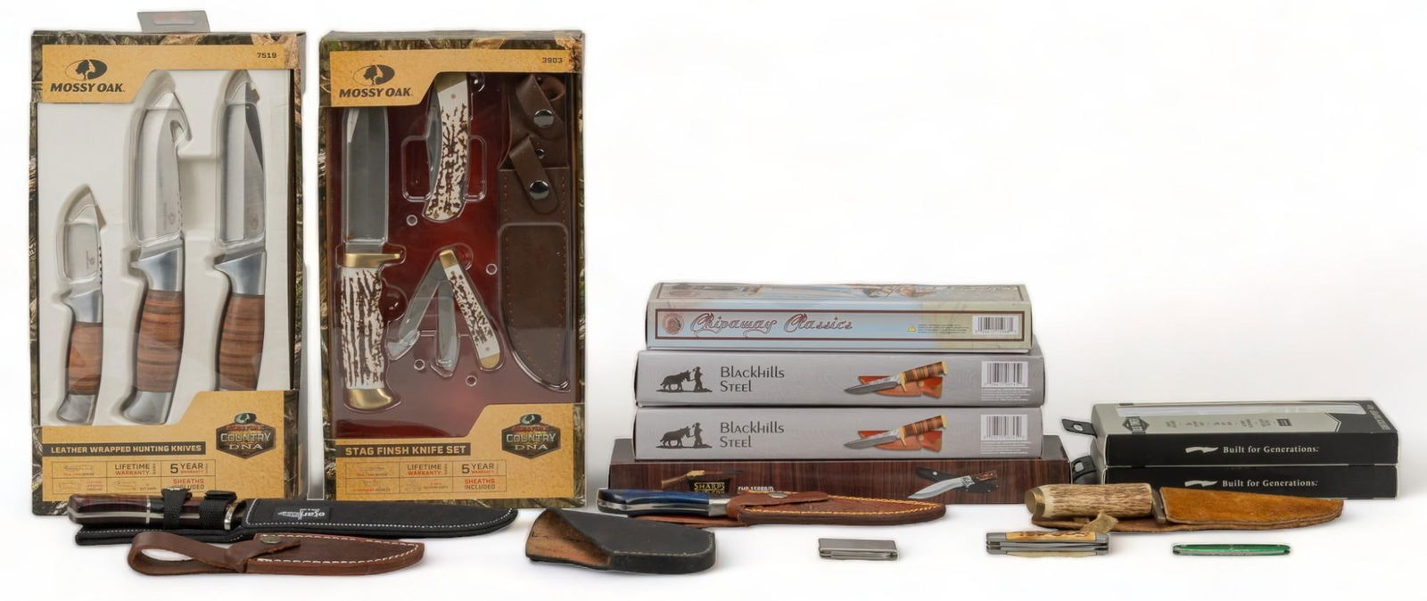 Collection of 14 Mixed Hunting & Pocket Knives: Includes: -Mossy Oak Country DNA 3 knife set in box; stacked leather -Mossy Oak Country DNA 3 knife set; stag finish -2 x Old Timer Gunstock Trapper folding knife in box -Ozark Mountain SA35 hunting k