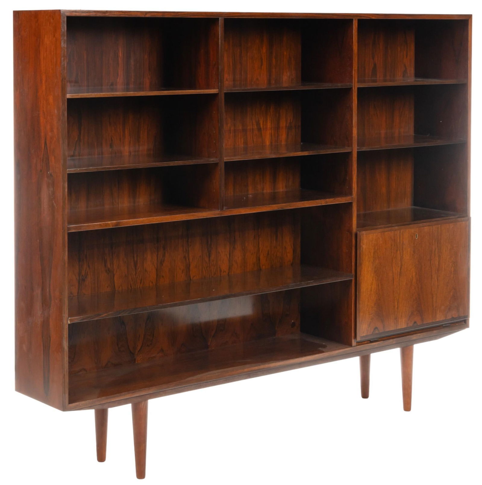Omann Jun (DNK) Mid-Century Bookcase: Omann Jun (Denmark) model no. 35 mid-century bookcase, featuring featuring six shelves above two wide shelves, beside two shelves above cabinet door that drops to reveal interior storage with mirrored