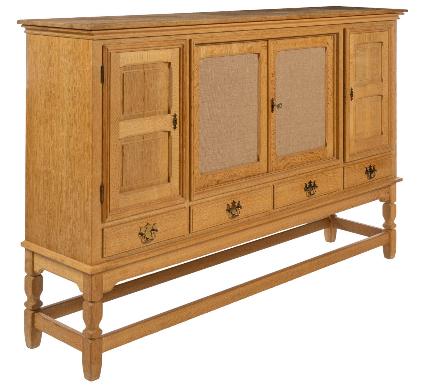 Henning Kjaernulf Style Credenza: Danish style mid-century high credenza, in the style of Henning Kjaernulf (Denmark) with four cabinet doors with wood panel design, with central doors clad in burlap fabric, opening on the left to ope