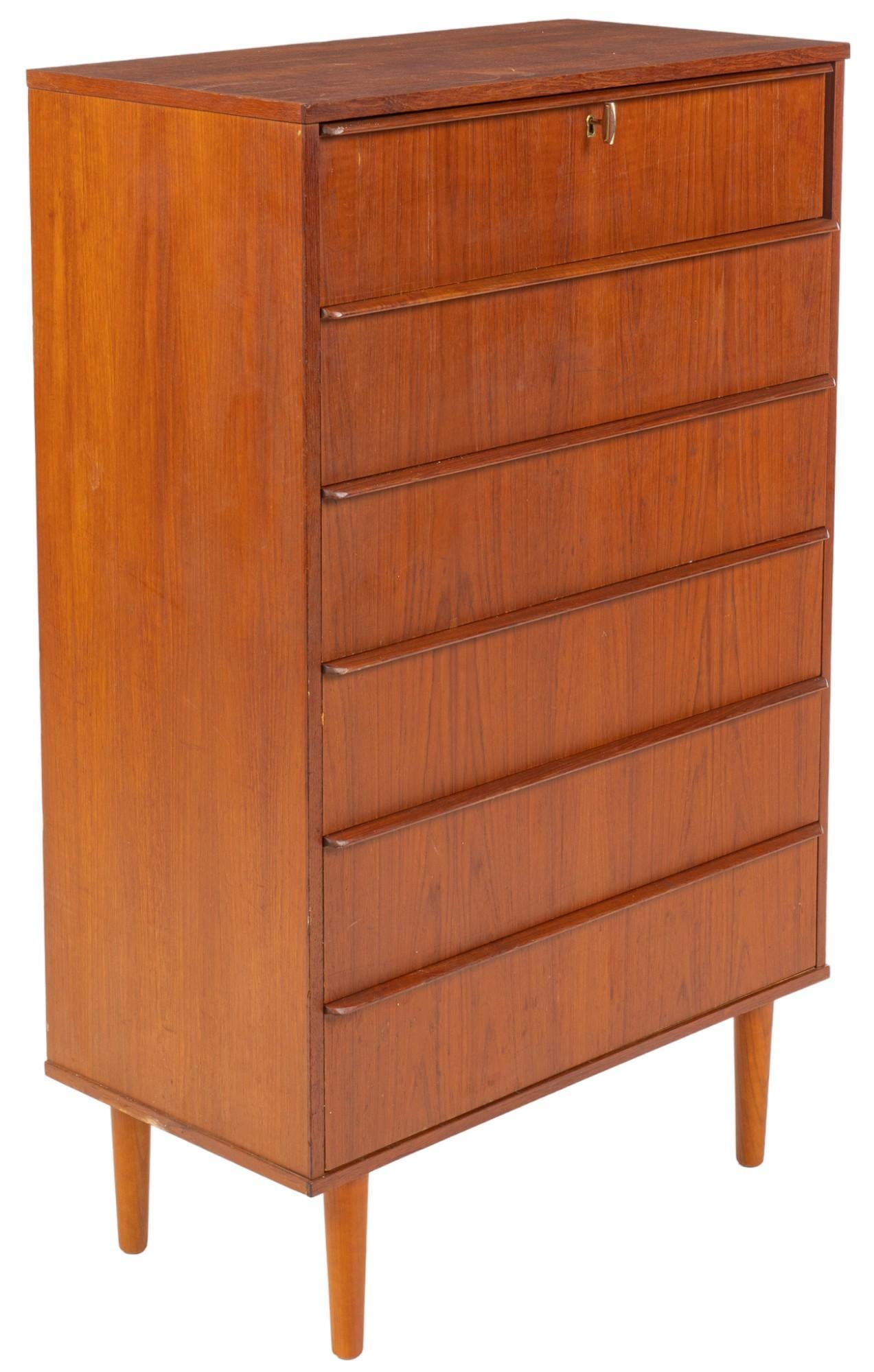 Danish Mid-Century Chest of Drawers: Danish mid-century chest of drawers / dresser, featuring stack of six drawers with wood pulls, with top drawer featuring key lock, supported on pin legs, includes key height 48.5 in. x width 30.5 in. 