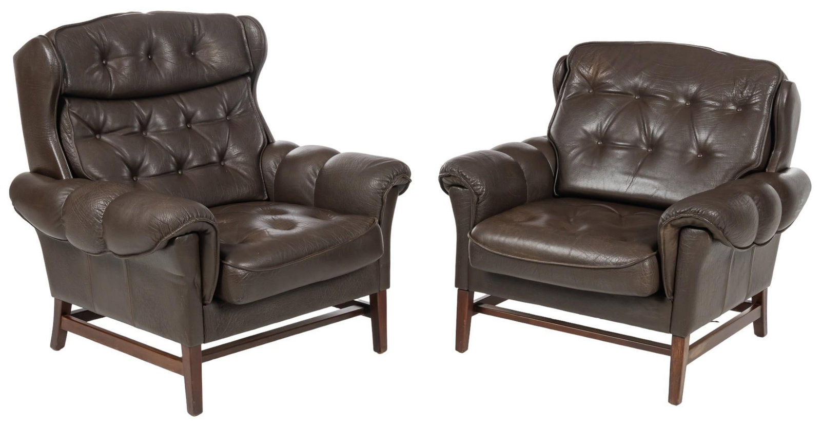 Pair of Mid-Century Leather Armchairs: Pair of Danish mid-century arm chairs featuring his and hers varying design, tufted cushions with brown height 37 in. x width 37 in. x depth 36 in. Shipping available for this lot through our partner 