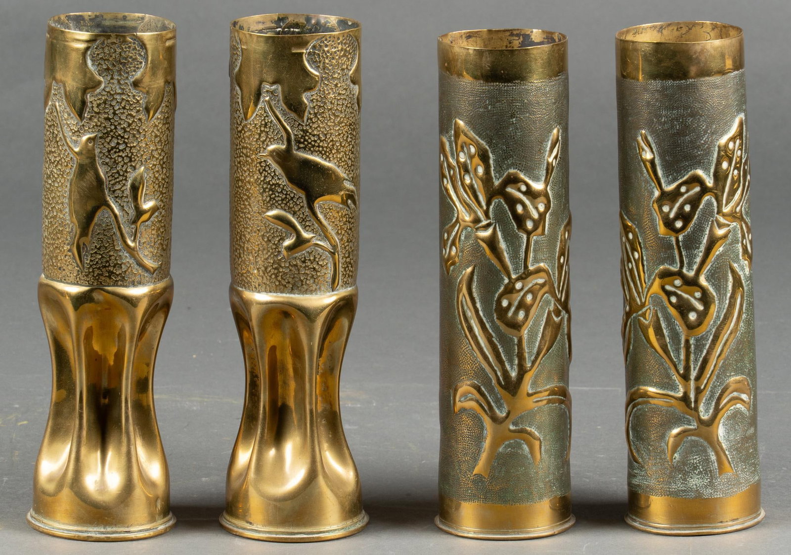 Set of 4 Engraved WWI Trench Art Vases: Includes: 4- French 75mm casings, both paired; one set featuring flowers; one featuring birds on branches with shields on the reverse Longest: 12 in. Shipping available for this lot through our partne