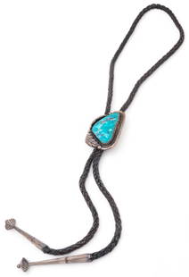 Western Bolo Tie: Western bolo tie with large ornamental stone slide, ornamental slide with inlaid turquoise, stone surrounded by vegetal motifs, braided leather cord, decorative metal aiguillettes, marked with