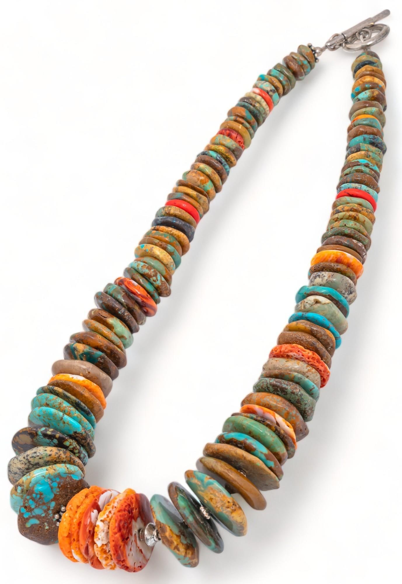 Blue and Red Rock Necklace: Blue and red rock necklace, varying size and shape rock like beads, pattern of rock beads and small silver beads, center cluster of red rock beads, metal toggle clasp Chain length: 18 in Provenance: