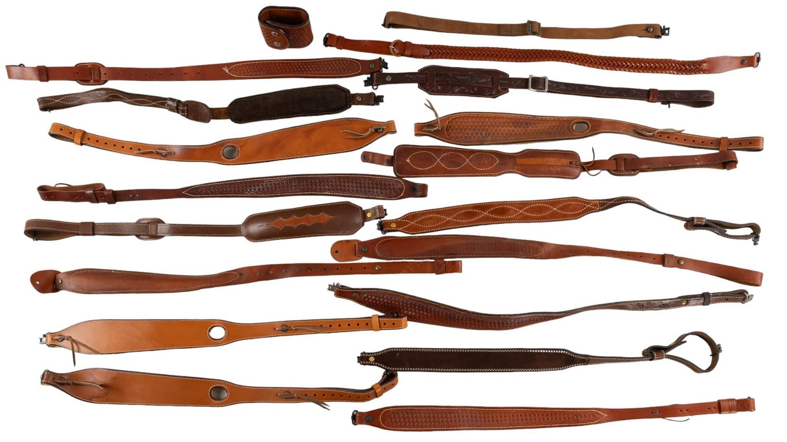 18 Leather Rifle Slings: Includes: 18 Leather Rifle slings of varying types of tooled braided and padded slings, 4 of them being Bianchi slings. Provenance: Property from the monumental lifetime collection of a distinguished 