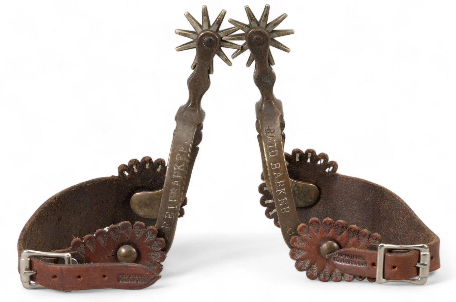 August Buermann Star Marked Hercules Bronze Spurs: August Buermann Hercules bronze spurs, floral engraved motif on heel band, embossed leather heel straps, marked "Hercules Bronze" and with star mark, monogrammed " R.B, Reid Barker" he