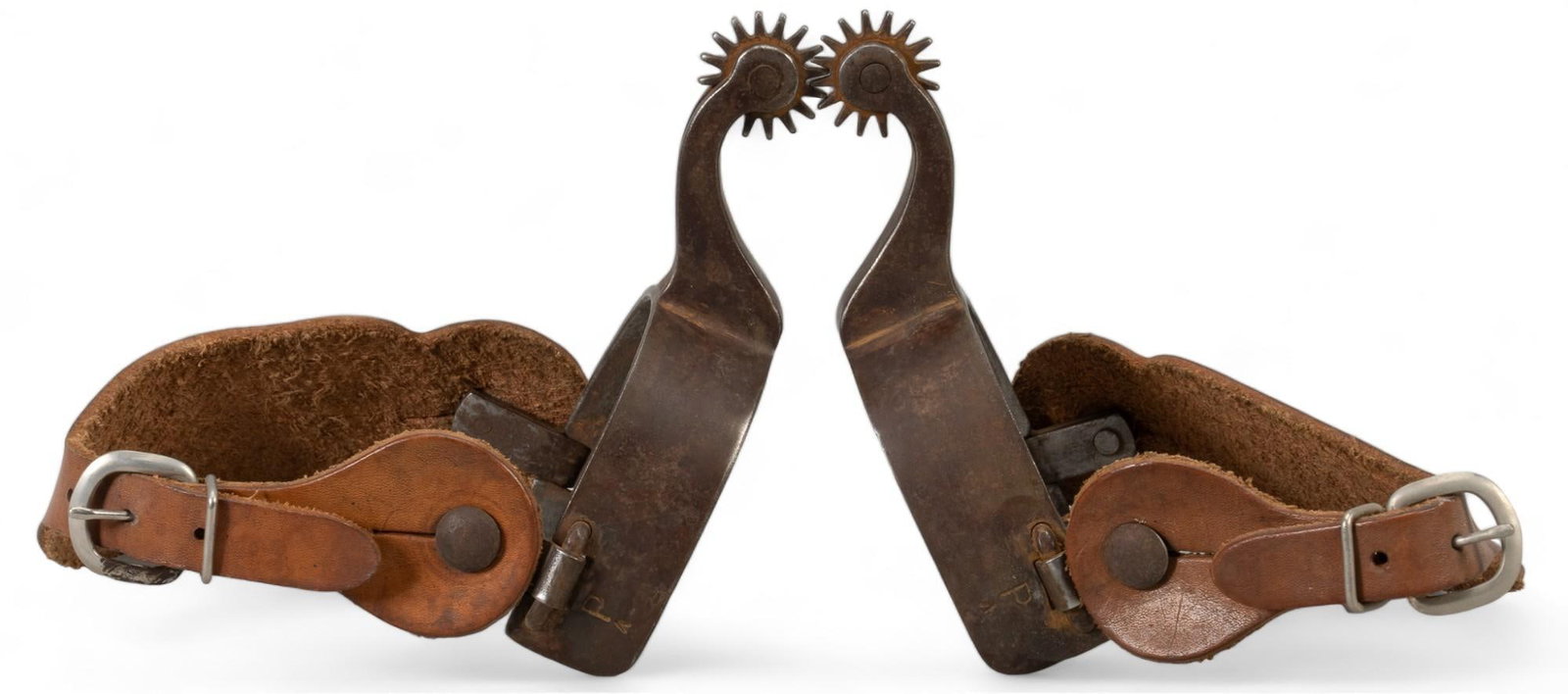 Pair of Silver Mounted Spurs: Pair of silver mounted spurs, silver mounted with the letter "D" on each spur, embossed floral detail on leather strap, marked with "P" heel strap shank length 6.5 in. x heel width 3.7