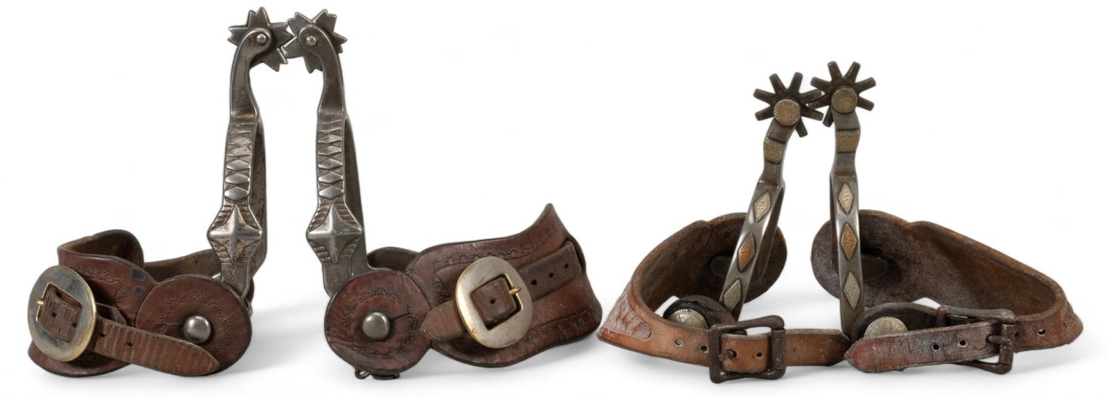 (2) Pairs of Cowboy Spurs: Two pairs of spurs, one is silver mounted with triangle pattern, small plain leather band, one has geometric engravings, both unmarked heel strap shank length 6 in. x heel width 3.75 in rowel diameter