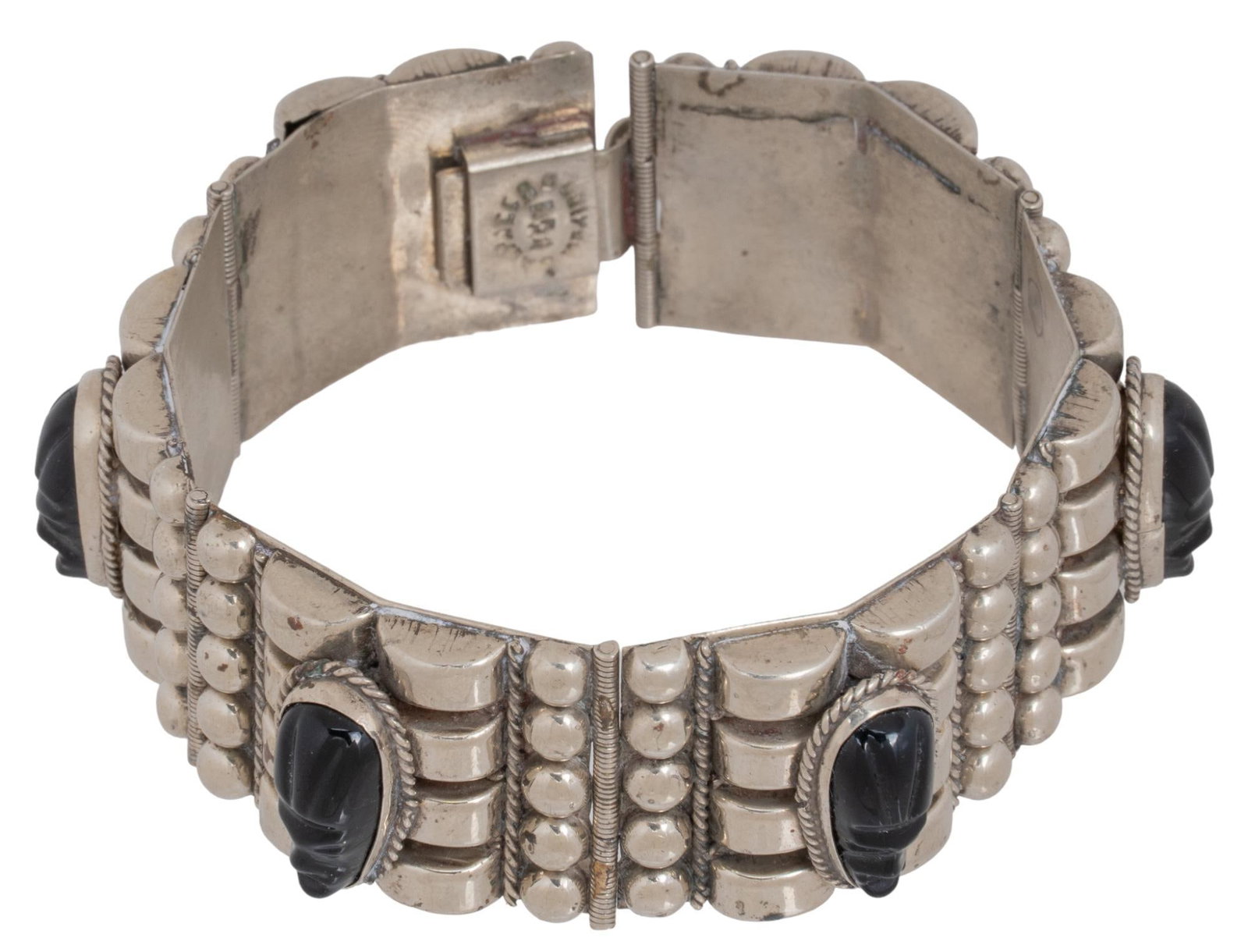 Sterling Silver and Carved Face Onyx Stones: Sterling silver carved face onyx stone, charm style bracelet with six separate pieces each with carved black onyx stone face, geometric soldered details on each piece, illegible mark on fastening Circ