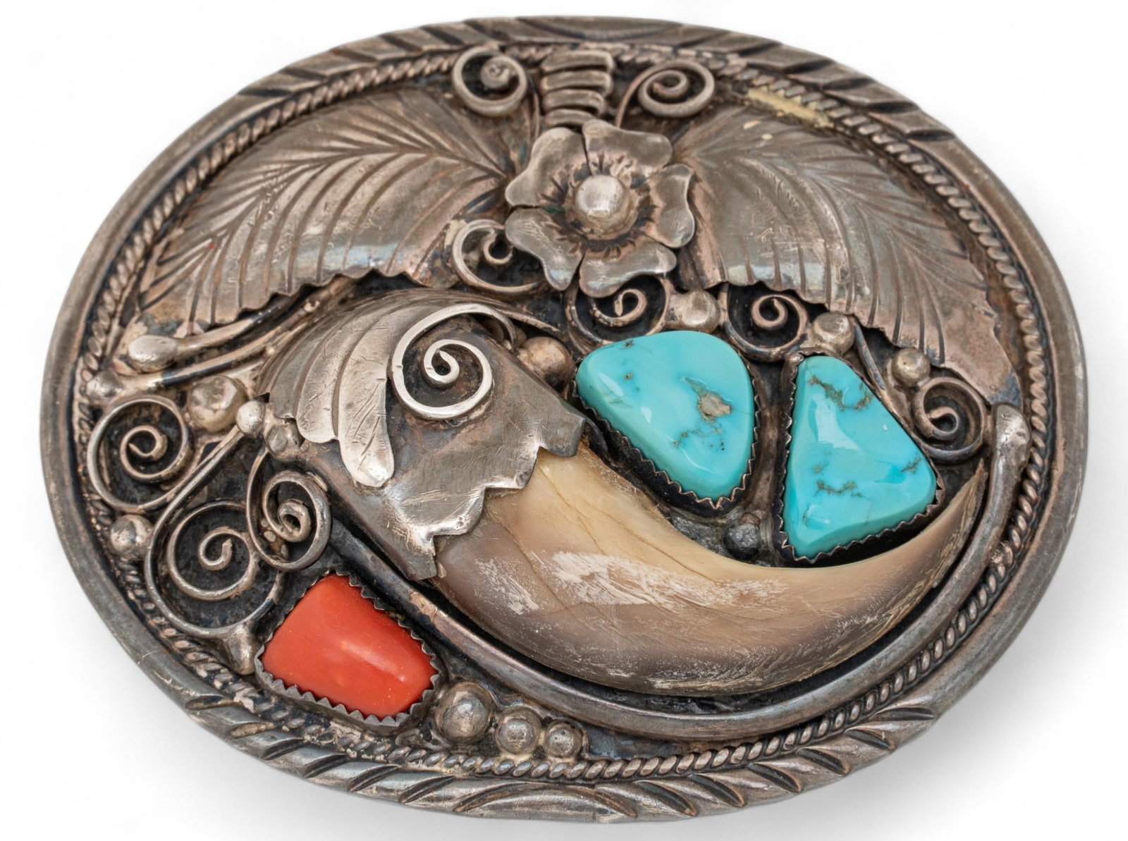 Sterling Silver and Turquoise Belt Buckle with Animal Claw: Sterling silver and turquoise belt buckle with animal claw, belt buckle with floral soldered details, two inlaid turquoise stones, one inlaid animal claw, one inlaid red stone Length 2.75 in x width 2