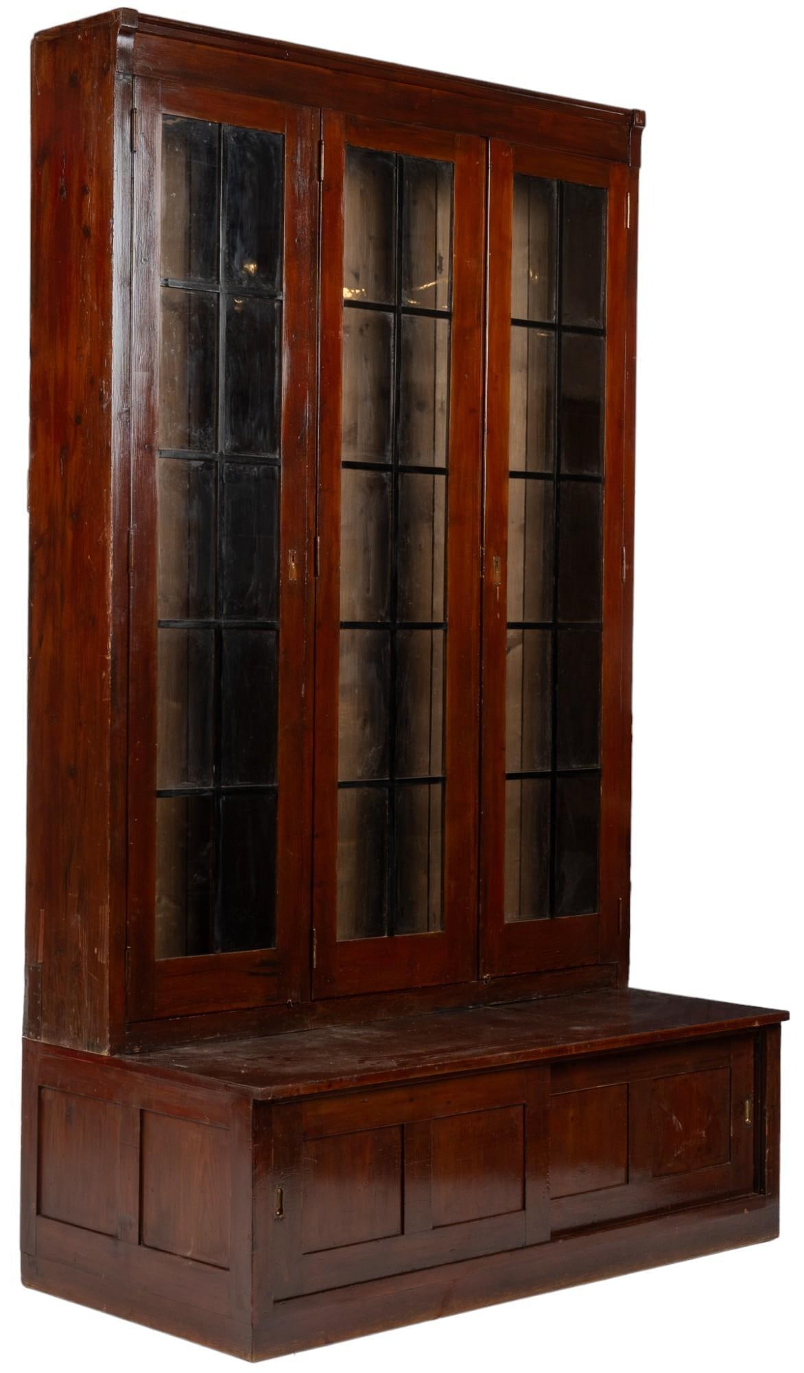 Monumental Wooden Display Cabinet: Monumental display cabinet, includes four shelves not pictured, glass paneling on display doors, metal keys holes on each cabinet door, small wood pannel cabinets below each glass section, closure mec