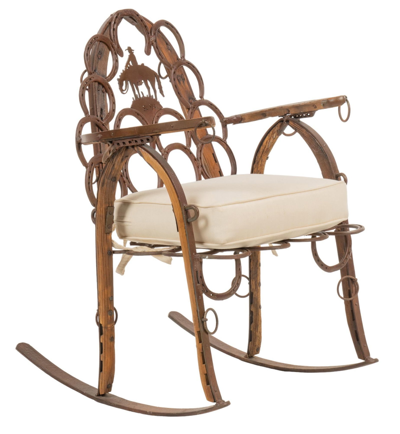 Horseshoe and Yoke Rocking Chair: Ranch style rocking chair, featuring frame composed of three horse yokes, with iron horseshoe accents fixed throughout, and splay featuring carved silhouette of cowboy on horseback, marked "EK 
