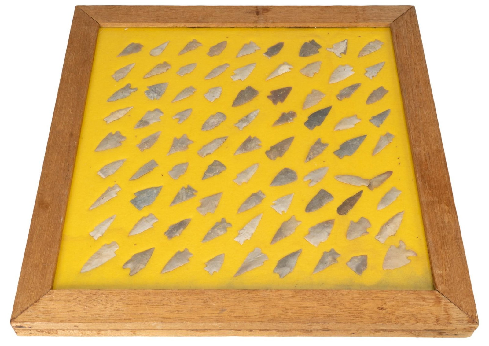 Collection of Projectile Points in Wood Box: Collection of projectile points in wood box, yellow background, points in various sizes, colors, and materials height 1.75 in. x width 23 in. x depth 23.5 in. Provenance: Property from the monumental 