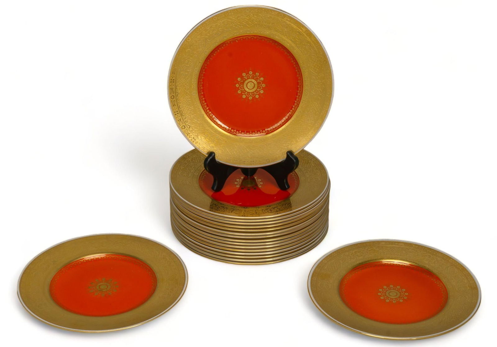 Vikki Carr | Minton Service Plates: Set of eighteen (18) matching dinner service plates, Minton (England) bone china, two-tone gold encrusted with central gold emblem on red, circa 19th century, marked with Minton mark on reverse of eac