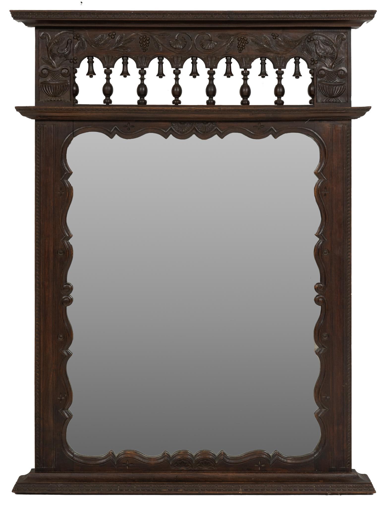 Carved Wall Mirror: Wall mirror featuring carved wooden frame, with pierced and carved section with additional cornice over turned spindles, over shaped frame height 54 in. x width 41 in. x depth 4 in. Provenance: Proper