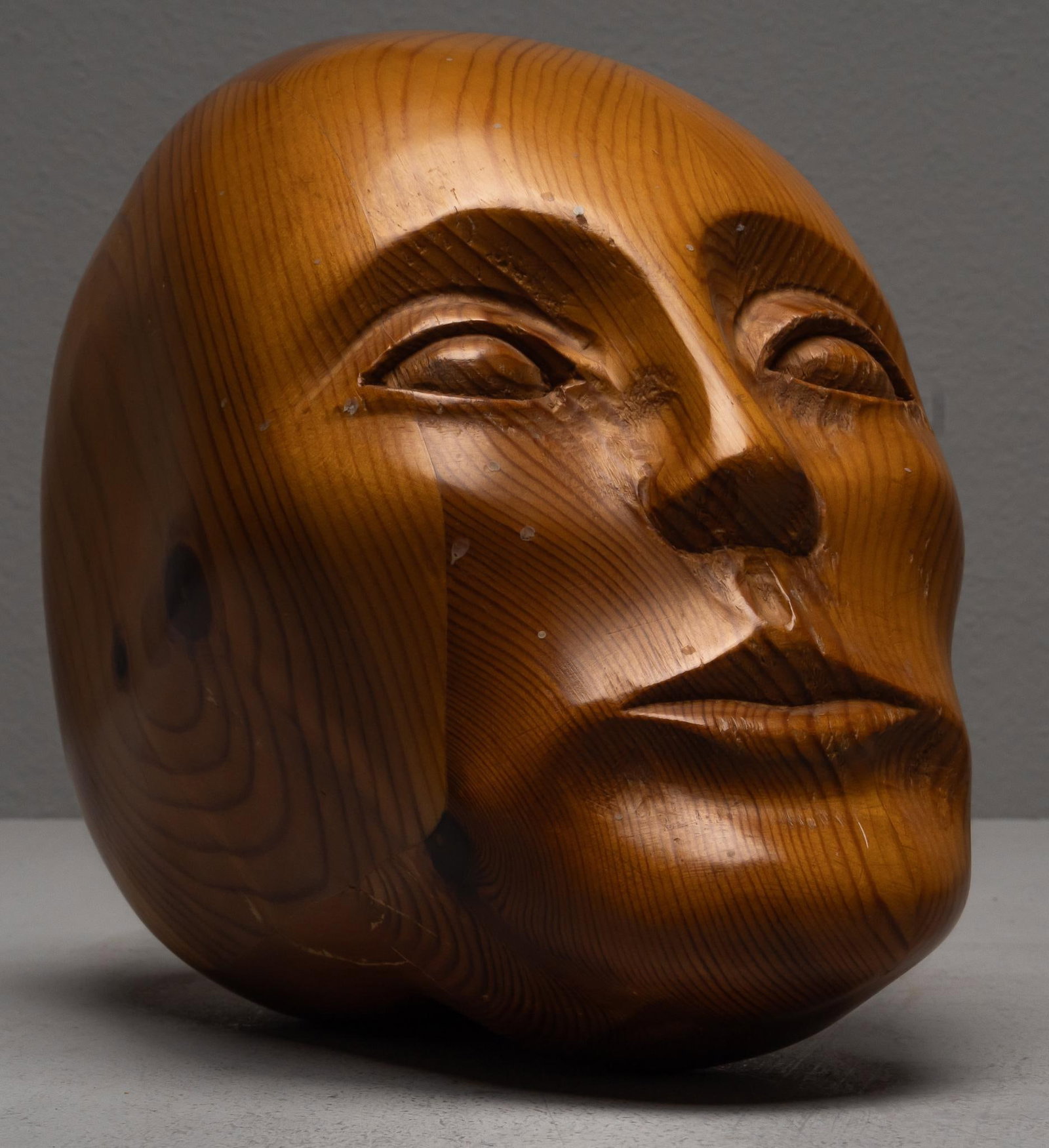 Hand-Carved Wooden Head Sculpture: Hand-carved wood, sculptural head, smooth stylized features height 8 in. x width 5.5 in. x depth 9.5 in. Provenance: Property from the personal collection of celebrated singer and philanthropist Vikki