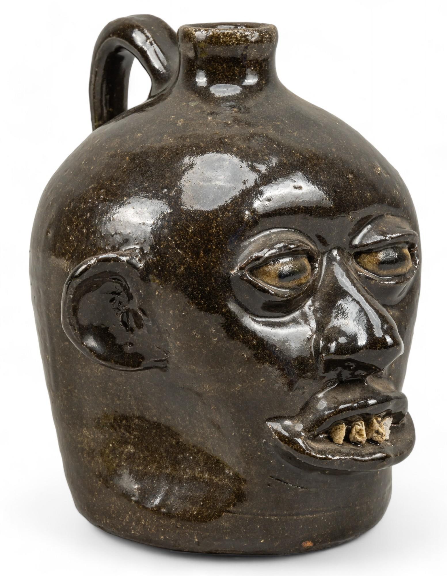 Lanier Meaders Face Jug: Lanier Meaders (Mossy Creek, Georgia, 1917-1998), face jug with rock teeth, stoneware with brown glaze, signed on base height 9 in. x width 8 in. x depth 7.5 in. Shipping available for this lot thr