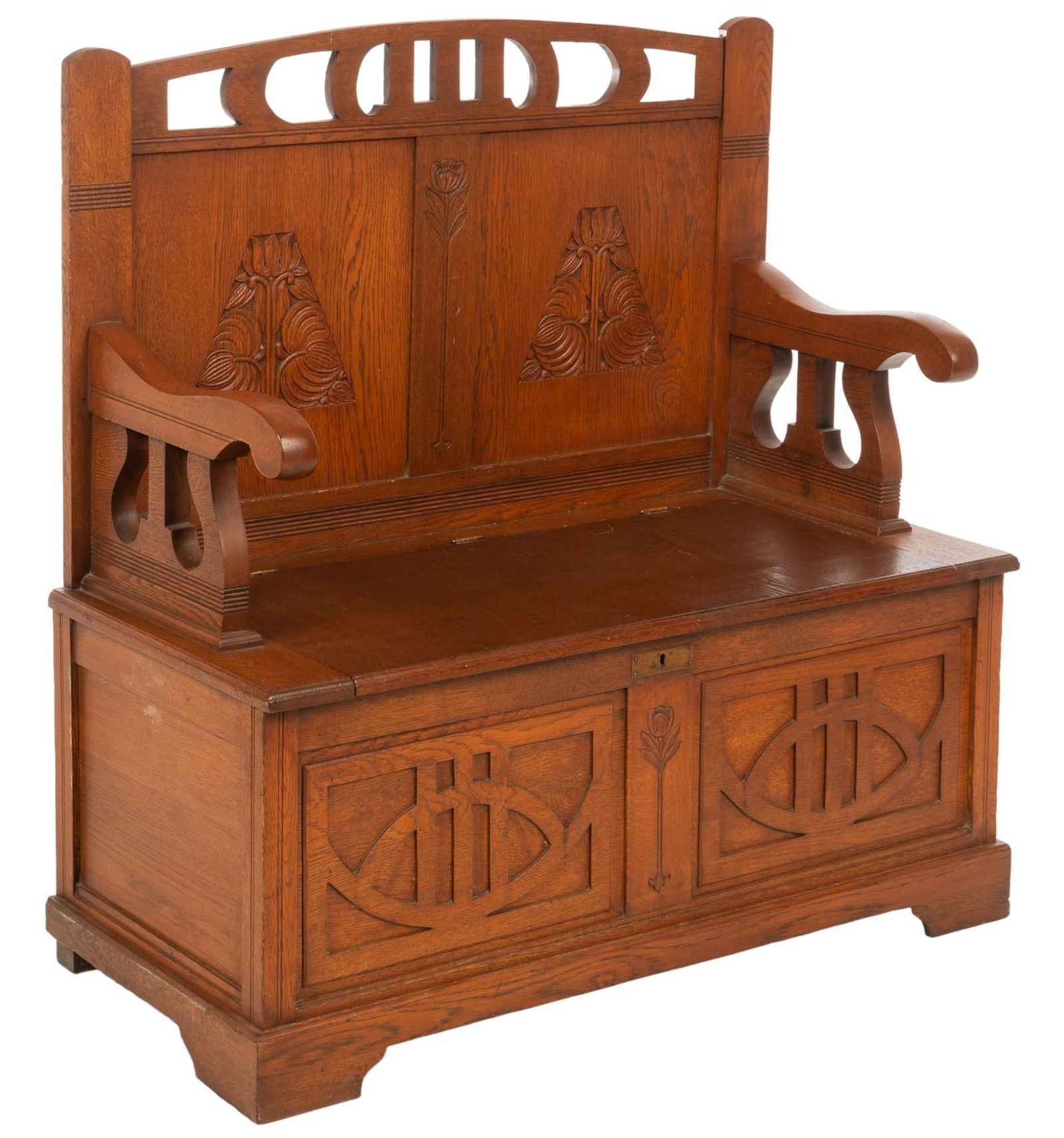Carved Settle: Carved settle featuring pierced crest over backrest with tooled floral motifs over hinged seat opening to interior storage, with tooled lower facade, and sloping armrests with shaped design, circa 189