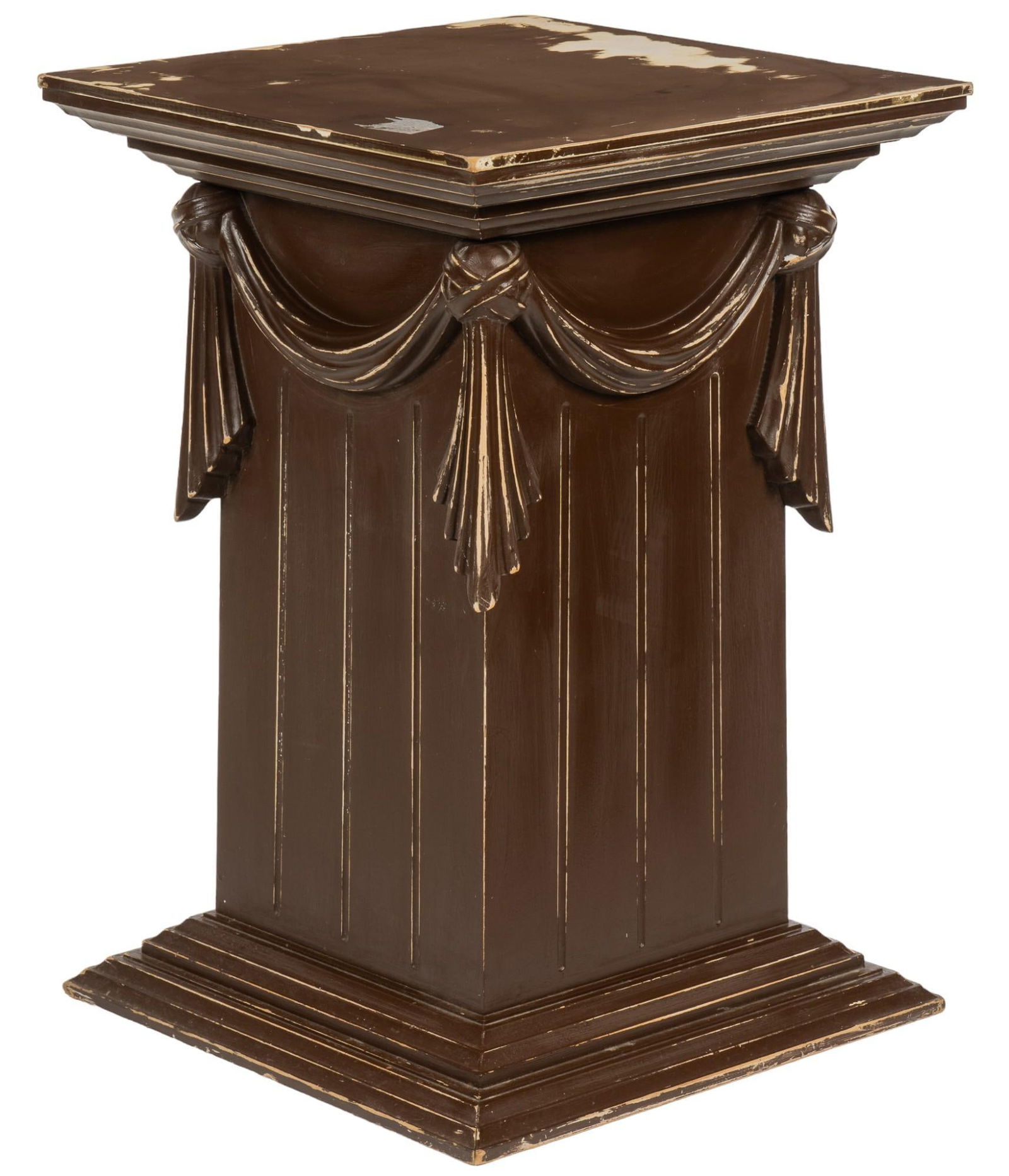 Carved Pedestal: Carved wooden pedestal with oversize top, carved fabric banner motif, and fluted details, with brown paint remnants height 29.5 in. x width 20 in. x depth 20 in. Shipping available for this lot thr