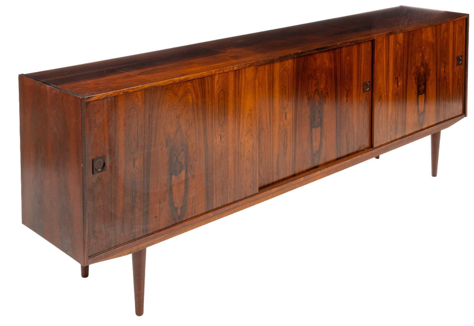 Danish Mid-Century Credenza: Danish mid-century sideboard with three cabinet doors with integrated wooden pulls that slide open to reveal interior storage spaces with single shelf on left and center areas, with right side door op