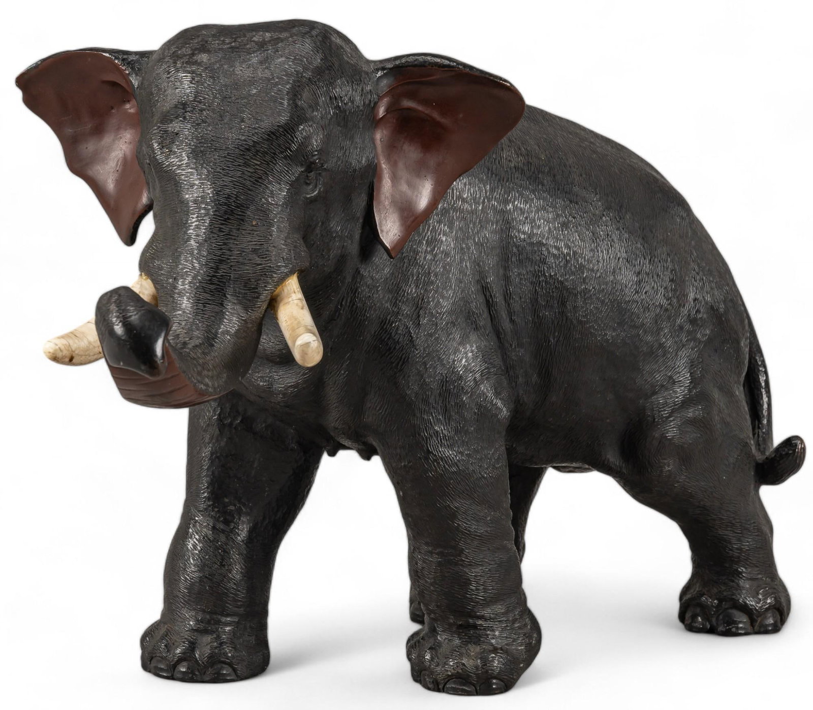 Bronze Elephant: Bronze sculpture depicting elephant with animal bone tusks, signed illegibly under foot height 12 in. x width 19 in. x depth 8 in. Provenance: Property from the collection of a Rockport, Texas gentlem