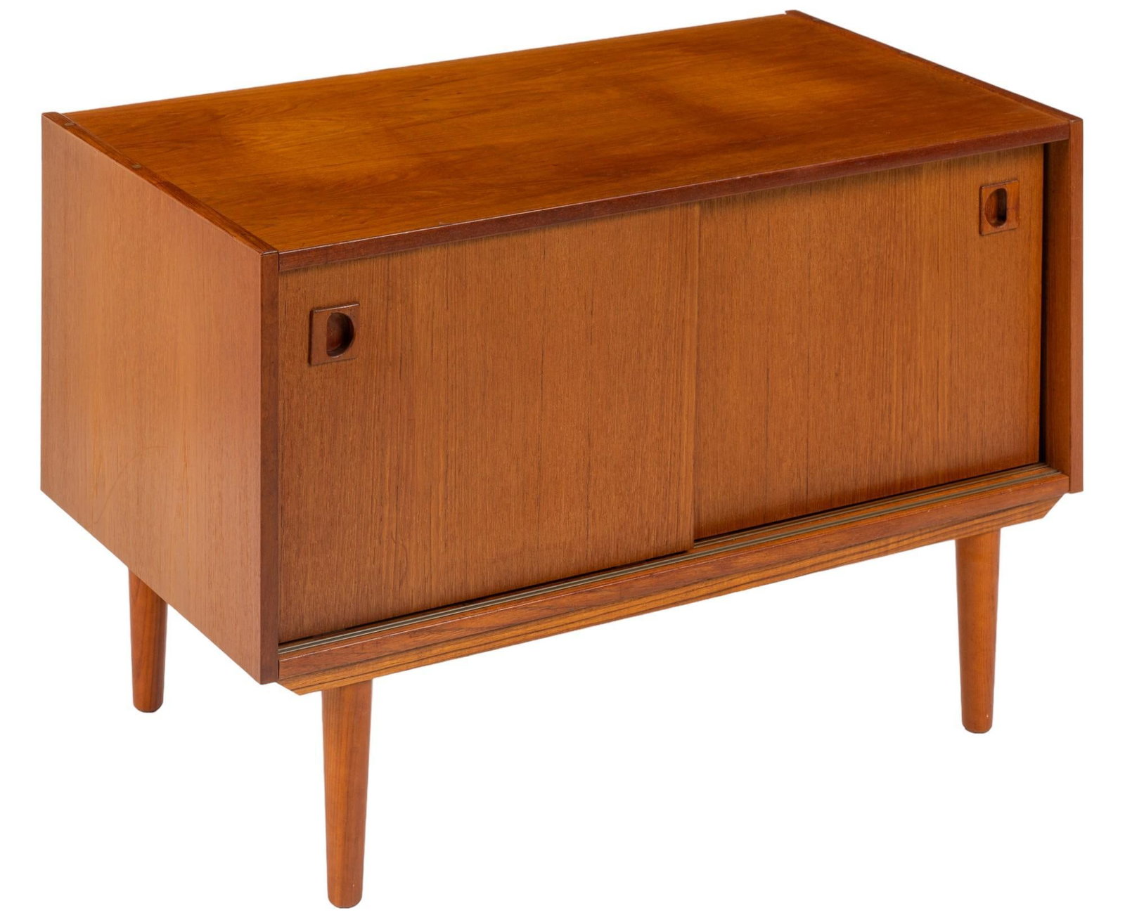 Small Danish Mid-Century Credenza: Small Danish mid-century credenza featuring pair of sliding doors with integrated wood pulls opening to interior storage, supported on pin legs height 23 in. x width 35 in. x depth 20 in. Shipping ava