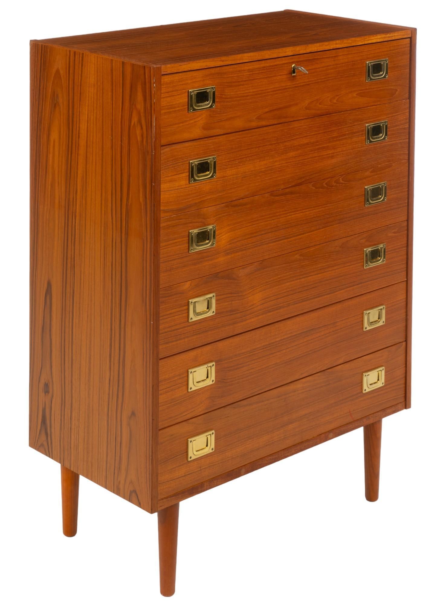 Danish Mid-Century Dresser: Danish mid-century dresser with six stacked frieze drawers with gold-toned metal pulls, and top drawer having key lock, supported on pin legs, includes one key height 41.5 in. x width 30 in. x depth 1