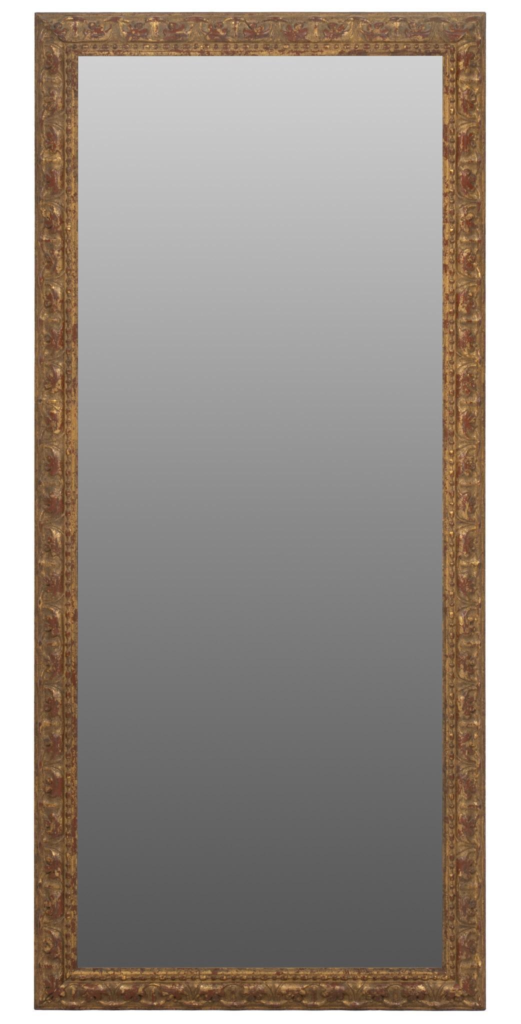 Wall Mirror: Wall mirror in carved wooden frame with gold and red paint height 44 in. x width 20 in. x depth 1 in. Shipping available for this lot through our partner 4CL; please request a shipping quote at shippi
