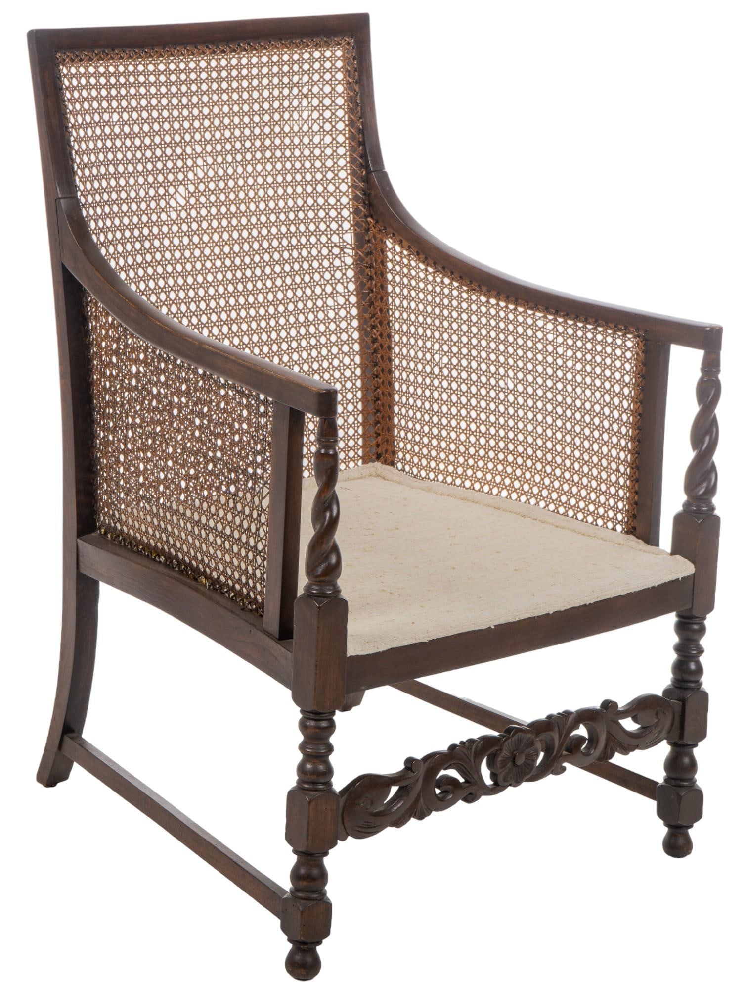 Cane Chair: Wooden chair featuring caned back and sides, sloping armrests ending in twisting supports, above turned front legs with carved front stretcher with botanical motif, circa early 20th century height 3