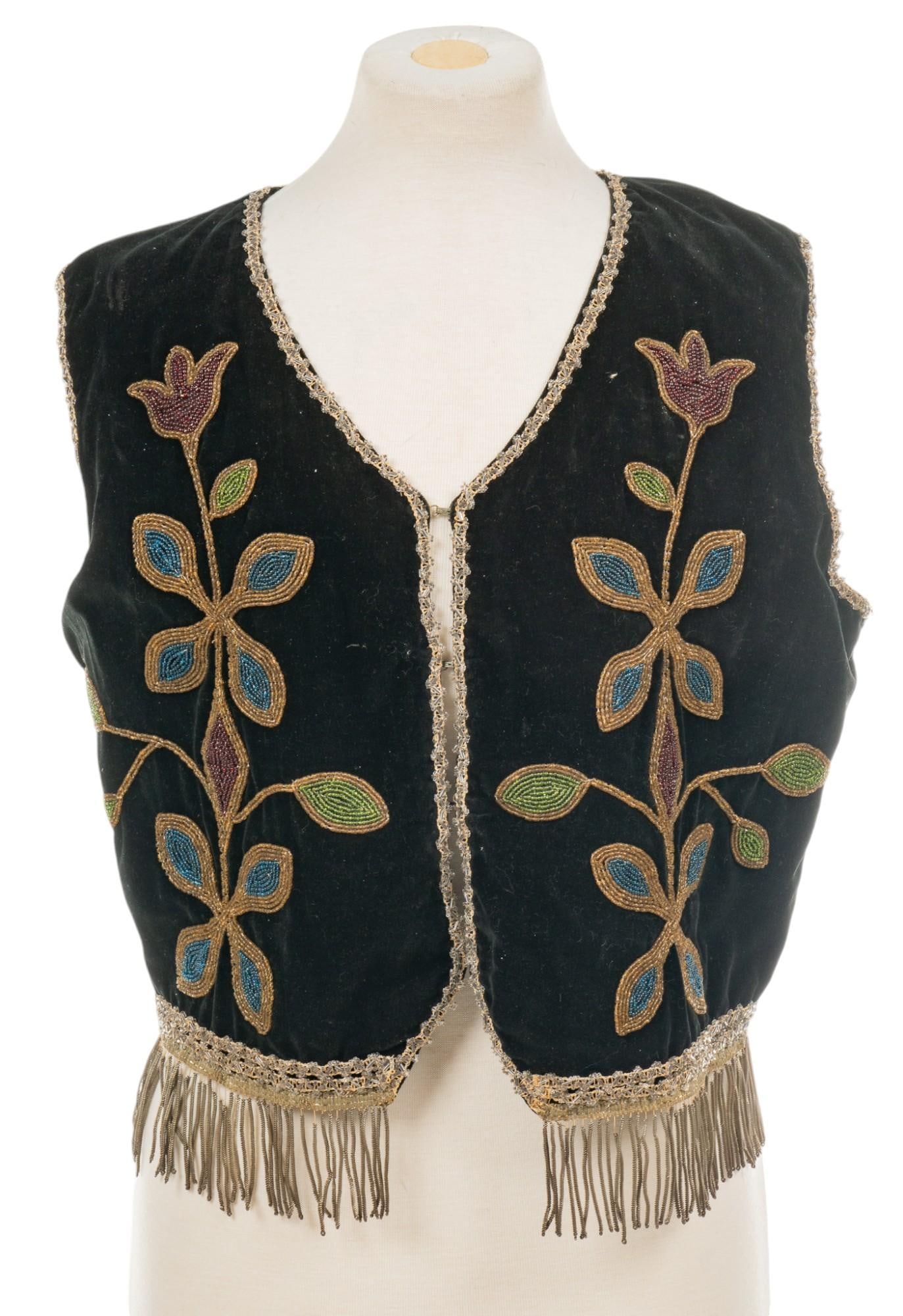 Beaded Vest: Beaded vest with velvet fabric, hand-stitched beaded details, with eagle and shield, and floral motifs height 20 in. x width 15 in. Shipping available for this lot through our partner 4CL; please r