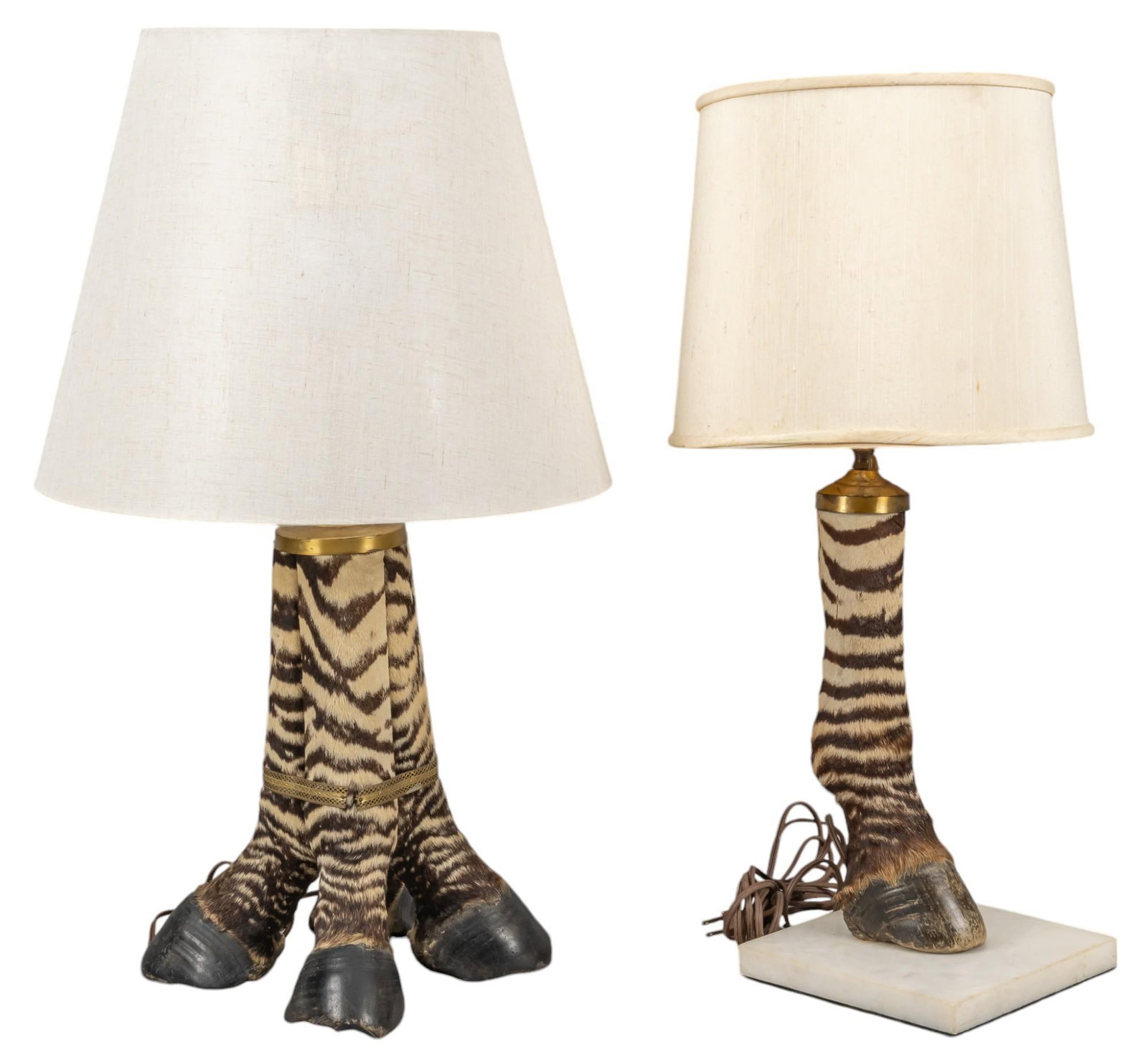 Pair of Zebra Hoof Lamps: Pair of zebra hoof lamps, one lamp has single hoof on stone base and lampshade, one lamp with four hoofs to create base, working condition height 27.5 in. x width 15 in. x depth 15 in. Shipping availa