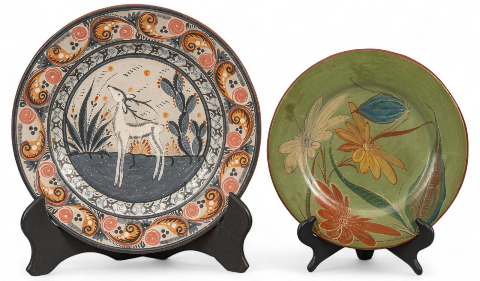 Pair of Tonala (Mexico) Chargers: Pair of Tonala (Mexico) chargers, hand painted, with smaller having floral motifs over green background, and larger having deer and cactus motifs, a hook for hanging on rear side, signed "Mexico&#